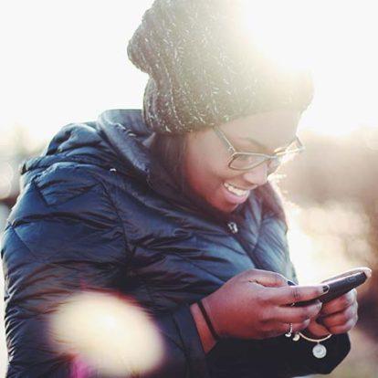 a woman in a puffy jacket looking at her phone