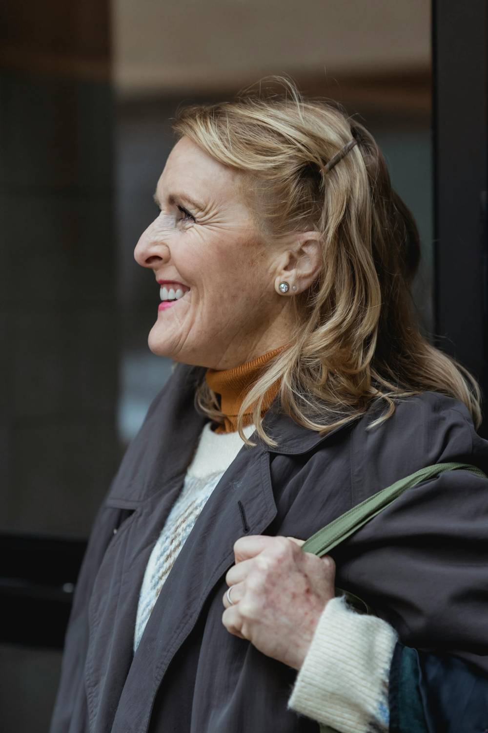 a smiling woman in a black coat